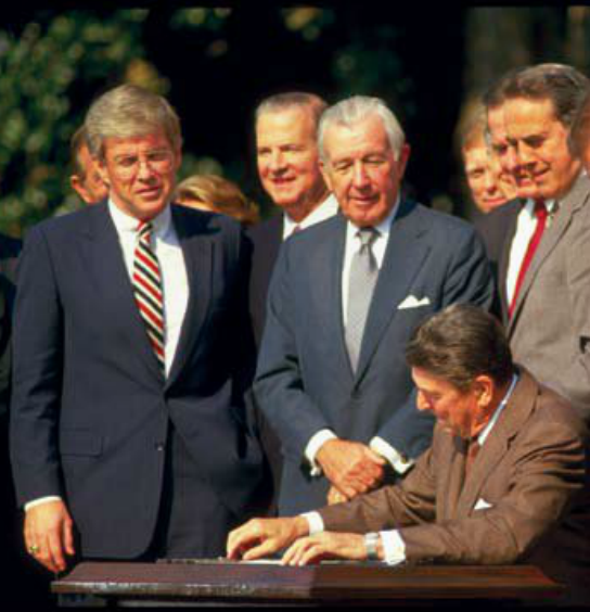 Then-Congressman Kemp watching President Reagan sign the tax reform bill of 1986